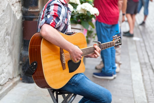 Joven guitarrista tocando en la calle