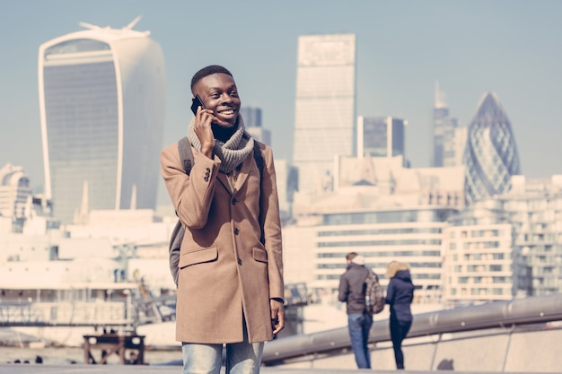 Joven hablando por celular con la ciudad de Londres