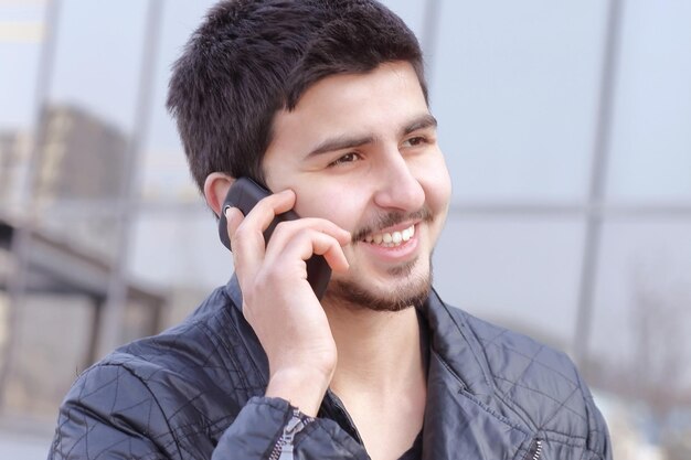 Joven hablando por un teléfono móvil en la calle