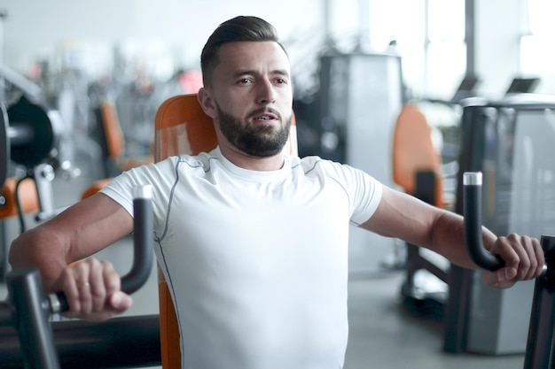 Joven hace entrenamiento con pesas en el gimnasio