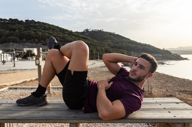 Joven haciendo abdominales al aire libre