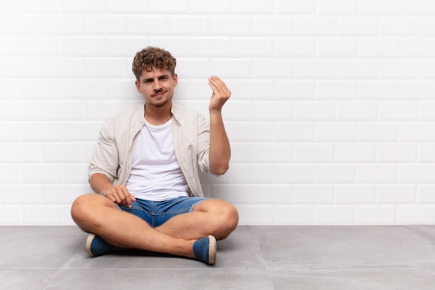 Foto joven haciendo capice o gesto de dinero