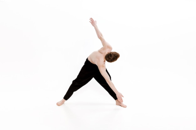 Joven haciendo ejercicios de yoga foto de estudio sobre fondo blanco.