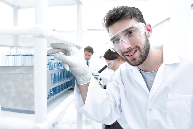 Foto un joven haciendo un experimento en un laboratorio químico.