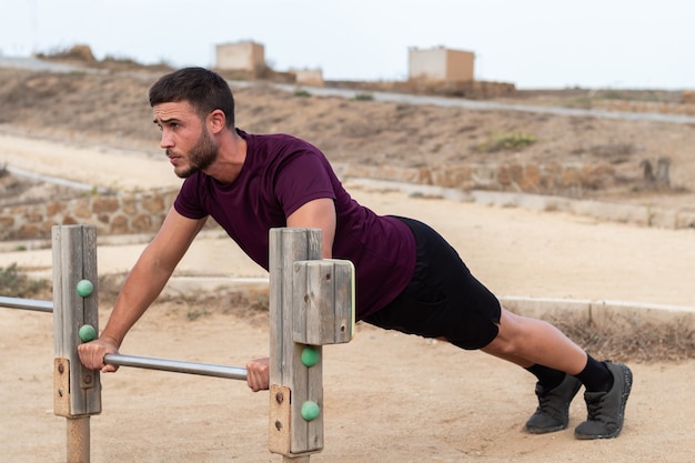 Joven haciendo flexiones en un parque al aire libre