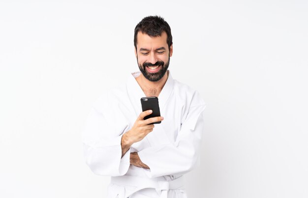 Joven haciendo karate enviando un mensaje con el móvil