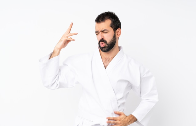 Joven haciendo karate sobre aislado con expresión cansada y enferma