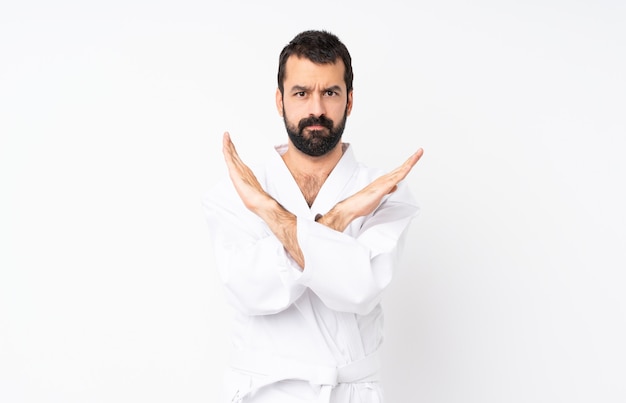 Joven haciendo karate sobre aislado haciendo ningún gesto