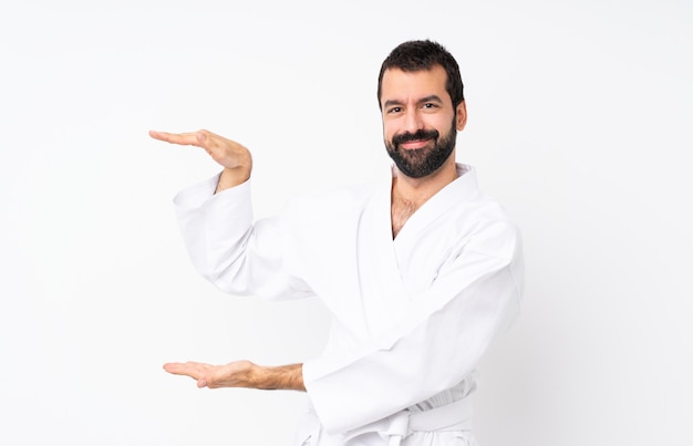 Joven haciendo karate sobre copyspace holding aislado para insertar un anuncio