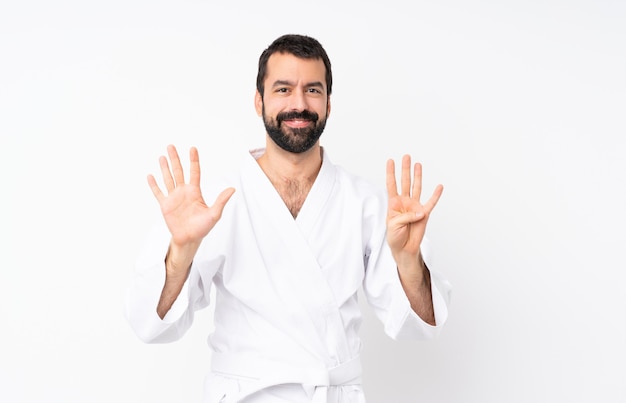 Joven haciendo karate sobre recuento aislado nueve con los dedos