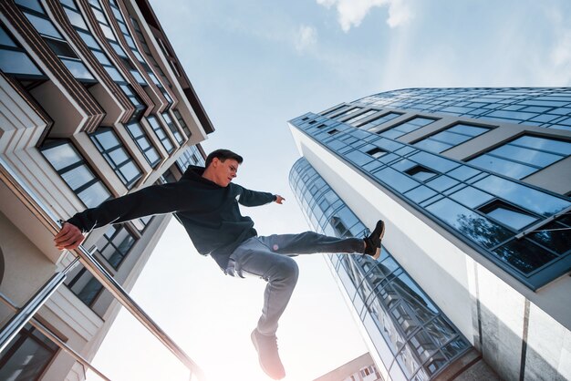 Joven haciendo parkour en la ciudad durante el día. Concepción de deportes extremos.