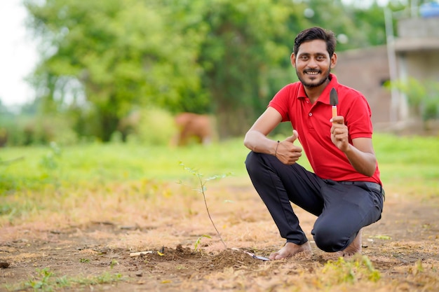 Joven haciendo plantación de árboles en el campo