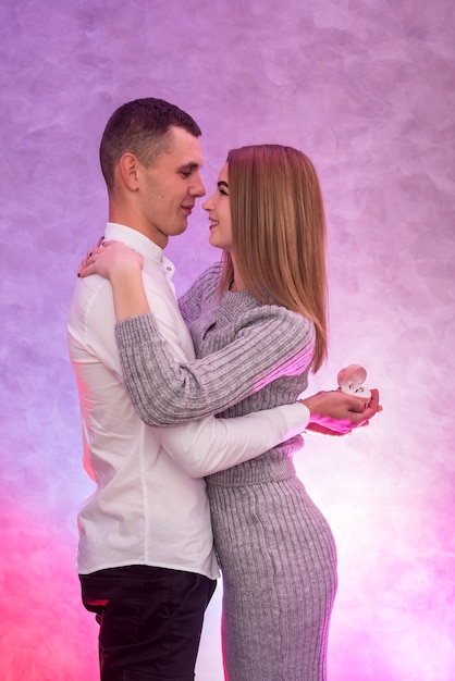 Joven haciendo propuesta con anillo de oro con diamantes a su chica. Sorpresa de san valentin