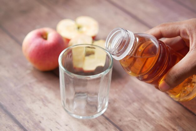 Joven haciendo pucheros en un vaso de jugo de manzana