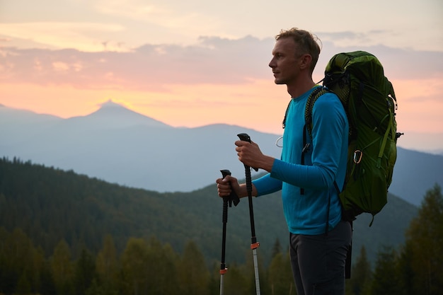 Joven haciendo senderismo en las montañas al atardecer