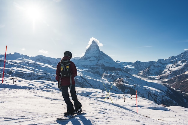 Joven haciendo snowboard en la estación de esquí de zermatt justo al lado del famoso pico Matterhorn