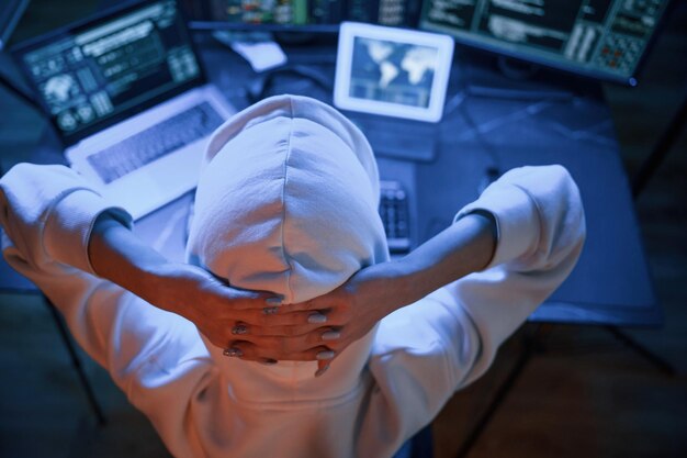 La joven hacker profesional está en el interior de la computadora con mucha información en las pantallas