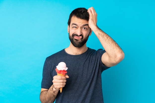 Joven con un helado de cucurucho sobre azul con una expresión de frustración y no comprensión