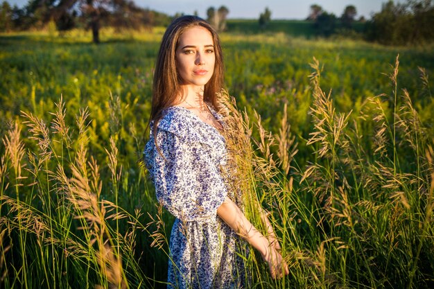 Joven hermosa chica europea en el sol poniente, en el campo