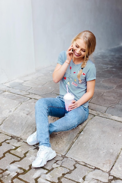 Joven hermosa chica rubia caminando por las calles de la ciudad