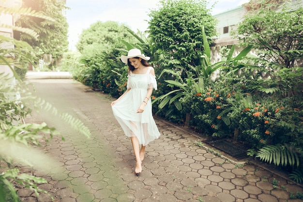 joven hermosa chica en un vestido blanco caminando