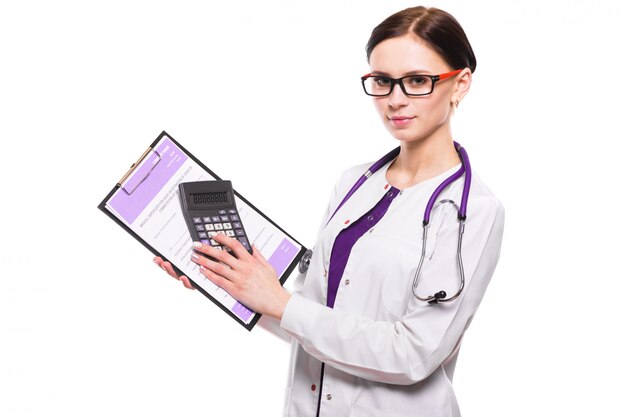 Joven hermosa doctora sosteniendo portapapeles y mostrando la calculadora en sus manos