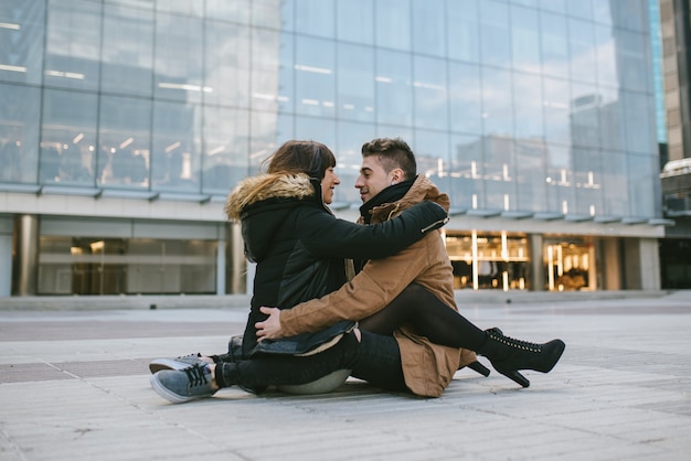 Joven hermosa enamorada pareja abrazándose en medio de la calle de una manera romántica