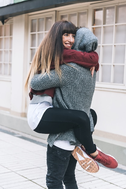 Joven hermosa enamorada pareja abrazándose en medio de la calle de una manera romántica