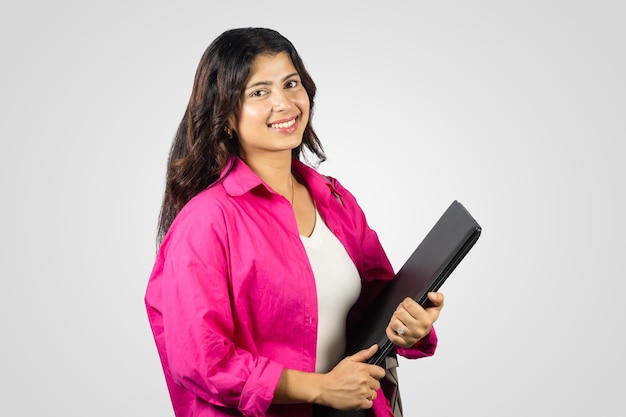 Joven y hermosa estudiante asiática nepalí en el extranjero estudia dando gestos con cuaderno en mano