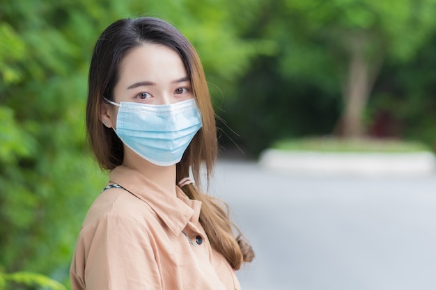 joven hermosa estudiante universitaria asiática usa una máscara para prevenir el coronavirus