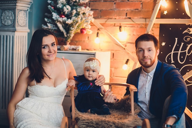 Joven hermosa familia feliz en ropa elegante con niño sonriente.