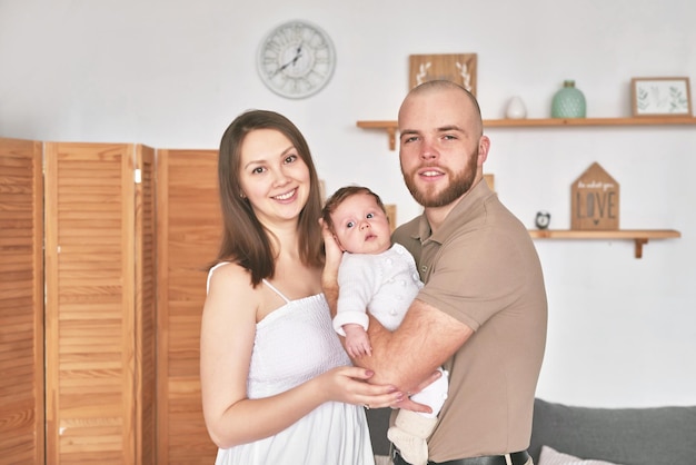 Joven hermosa familia Madre y padre sostienen al bebé recién nacido Felices padres e hijos Día de la madre y del padre