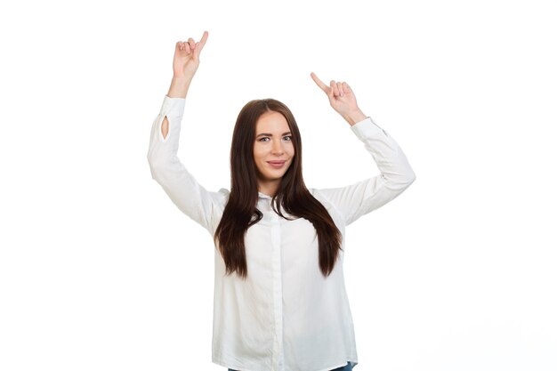 Foto una joven hermosa de fondo blanco señala con el dedo el lugar para ofertas promocionales o publicidad