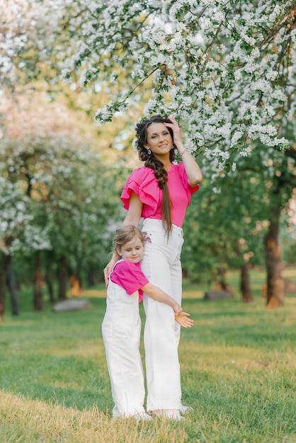 Una joven y hermosa madre está feliz y sosteniendo a su hija en sus brazos se están divirtiendo