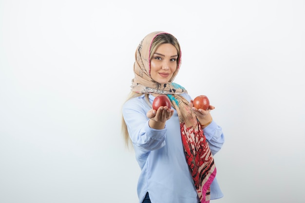 Joven hermosa modelo en colorido mantón con manzanas rojas