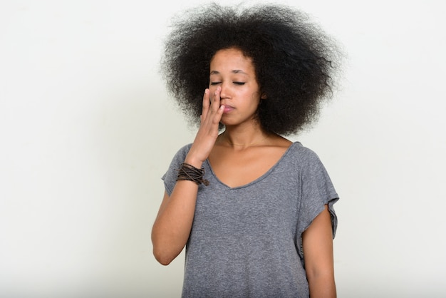 Joven hermosa mujer africana con cabello afro en blanco