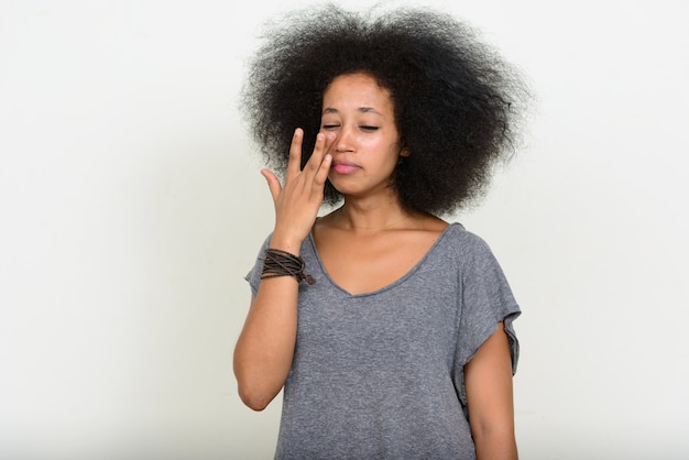 Joven hermosa mujer africana con cabello afro en blanco