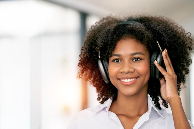 Joven hermosa mujer afroamericana relajándose y escuchando música con auriculares