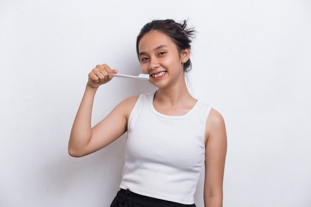 Joven hermosa mujer asiática cepillarse los dientes aislado sobre fondo blanco.