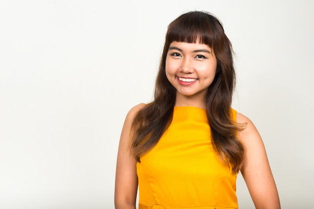 Joven hermosa mujer asiática contra el espacio en blanco