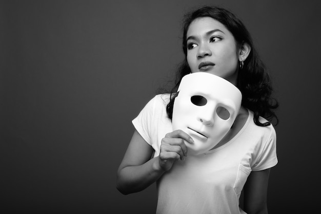 Joven hermosa mujer asiática contra la pared gris en blanco y negro