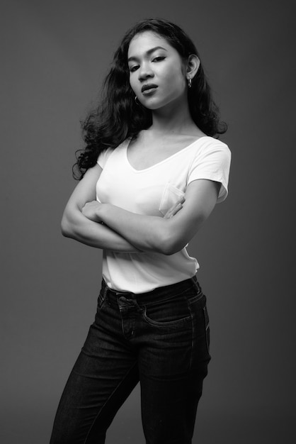 Joven hermosa mujer asiática contra la pared gris en blanco y negro