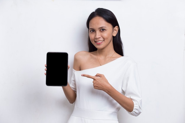 Joven hermosa mujer asiática demostrando teléfono celular móvil aislado sobre fondo blanco.