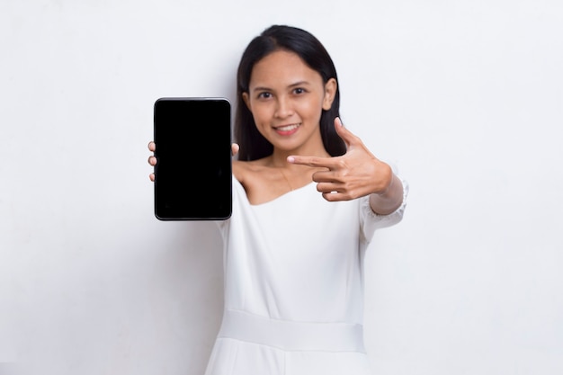 Joven hermosa mujer asiática demostrando teléfono celular móvil aislado sobre fondo blanco.