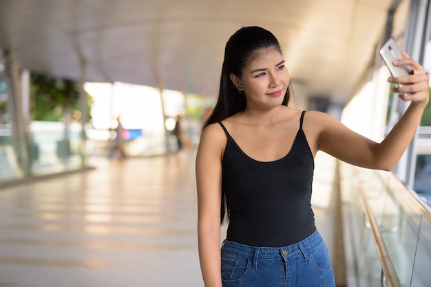 Joven hermosa mujer asiática explorando la ciudad