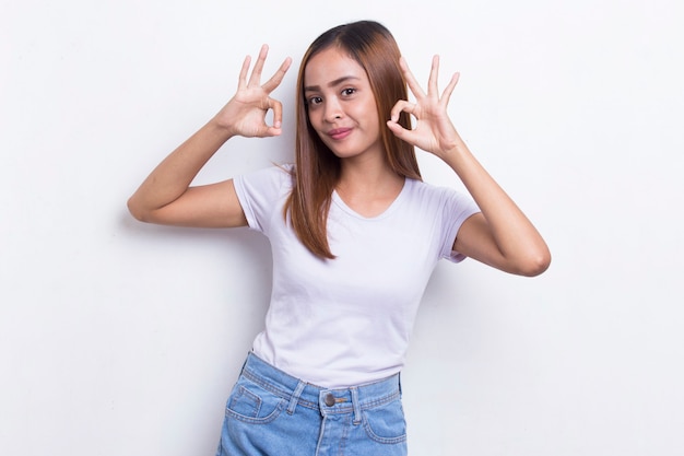 Joven hermosa mujer asiática con gesto de signo ok tumbado aislado sobre fondo blanco.