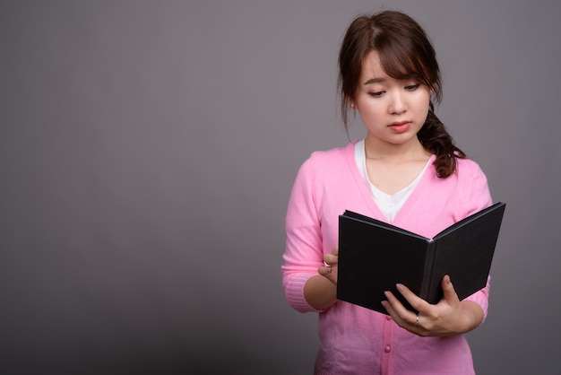 Joven hermosa mujer asiática con libro o diario