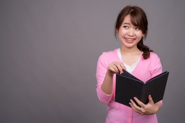 Joven hermosa mujer asiática con libro o diario