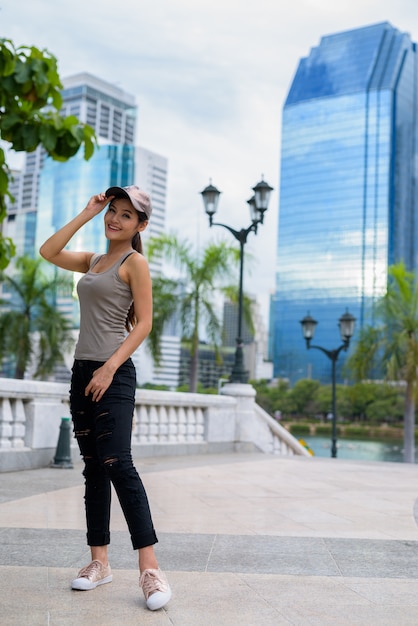 Joven hermosa mujer asiática relajante en el parque