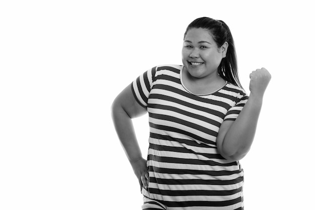 Joven hermosa mujer asiática con sobrepeso aislada contra la pared blanca en blanco y negro